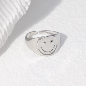 Detailed view of silver adjustable stainless steel ring with a minimalist smiley face pattern