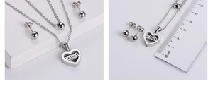Macro view showing silver heart necklace with 'mama' engraving and size measurement scale