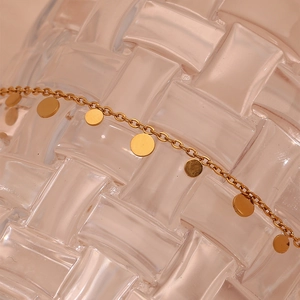 Macro shot of 18K gold plated minimalist necklace with delicate round coin pendants