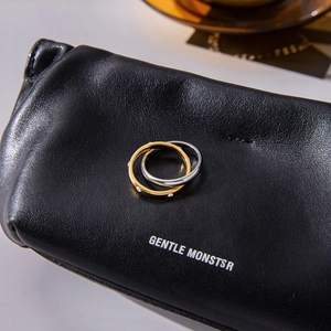 Detail of interlocked gold and silver stainless steel rings on premium black leather