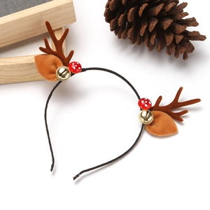 Détail d'un serre-tête renne de Noël avec bois bruns, cloches dorées et petits champignons