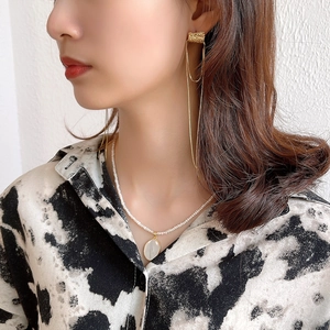 Elegant gold tassel earrings and mini pearl necklace set with oval pendant on model