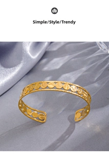 Detailed shot of 14K gold plated cuff bracelet with unique circular hollow texture on silk