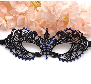 Detail of black lace masquerade mask with blue rhinestones on floral background