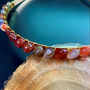 Close-up of handmade bridal headband with polished agate stones and gold wire wrapping
