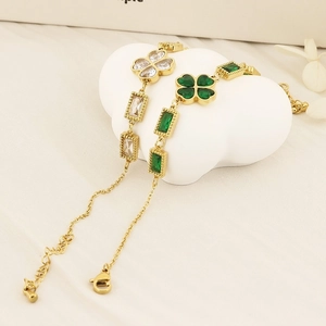 Close-up of gold stainless steel bracelet featuring clover and emerald zircon details