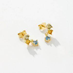 Macro shot of S925 silver gold-plated stud earrings with vertical green, orange and blue stones