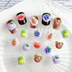Cute fruit and bear nail art resin charms displayed on a white decorative plate