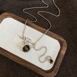 Elegant silver box chain necklace featuring a brown tiger eye pendant in vintage style