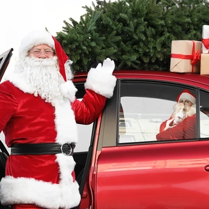 Christmas Santa Claus car window decal with festive tree and gift boxes on a red vehicle