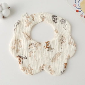 Macro detail of breathable cotton gauze baby bib with vintage floral print and button
