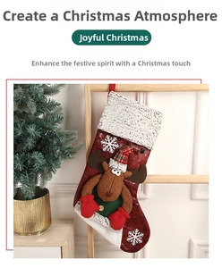 Détail d'une chaussette de Noël rouge avec renne 3D et flocons de neige blancs brodés