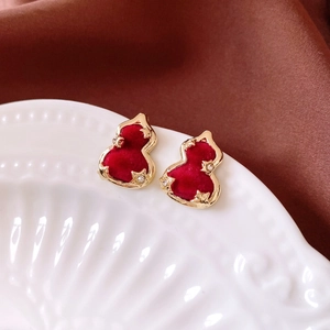 Macro view of red flocked gourd earrings with gold edges and sparkling rhinestones