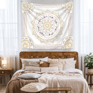 Detail view of a floral mandala tapestry hanging above a bed in a cozy boho bedroom