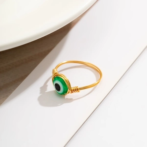 Detail of handcrafted gold wire wrapped ring with a green opal devil's eye bead
