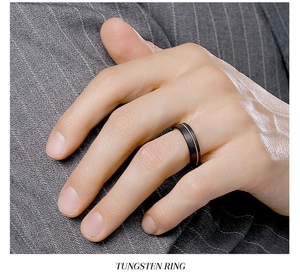 Close-up of black tungsten ring on model wearing a charcoal pinstripe business suit