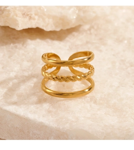 Close-up of golden multi-layer twisted rope ring on white crystal stone base