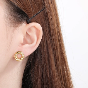 Close-up of model wearing 18K gold-plated twisted earrings with sparkling crystals