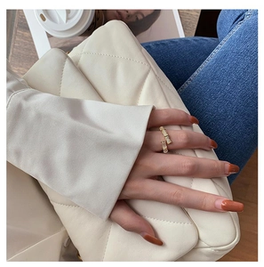 Detail of gold bamboo style open ring with zircon accents worn on model hand