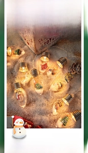Close-up of LED Christmas wishing ball lights with miniature snowmen and warm yellow glow