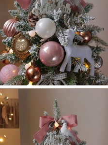 Detail of pink and white Christmas ornaments and flocking reindeer on tree branches