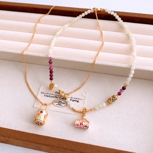 Détails de colliers en perles et or avec émail floral et pendentifs sac à main rose