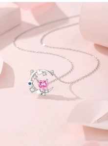 Detail of S925 silver necklace with pink heart gemstone, moon and star pendant charms
