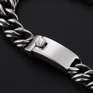 Macro shot of polished silver stainless steel Cuban chain bracelet with spring clasp
