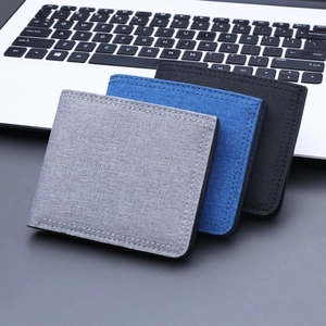 Slim canvas men's wallet set in grey, blue, and black displayed on a laptop keyboard