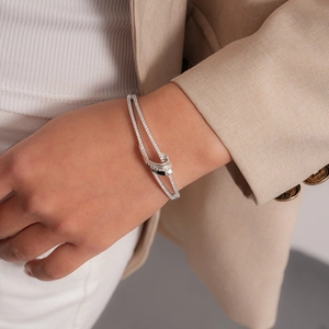 Detail of silver double-layered cuff bracelet with pavé cubic zirconia on wrist