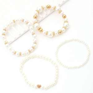 Detailed set of four beaded bracelets featuring white pearls and golden heart accents