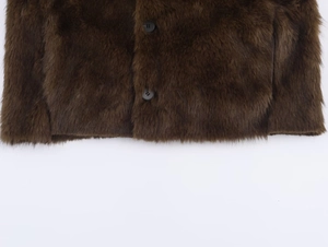 Gros plan détaillé d'une veste en fausse fourrure marron foncé avec boutons noirs ronds