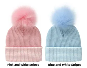 Detail of pink and blue striped knit hats with fluffy pom-poms for toddlers