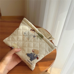 Detailed close-up of quilted cotton makeup bag with cute bear and rabbit prints