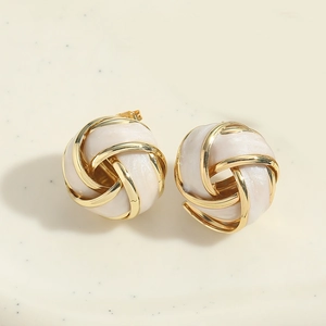 Detail of elegant gold-toned woven knot earrings with pearl-like resin center inlay
