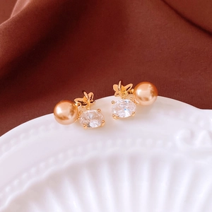 Gros plan sur boucles d'oreilles papillon dorées avec perles champagne et zircons ovales
