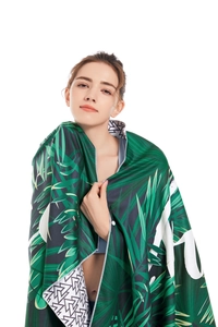 Macro detail of microfiber beach towel with tropical palm leaves and geometric pattern