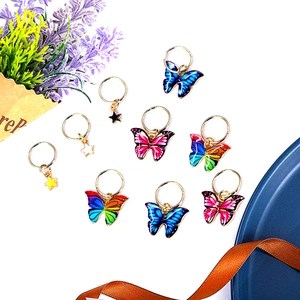 Detailed view of colorful enamel butterfly and star charms for hair braid styling