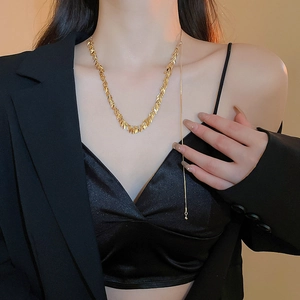 Primo piano della collana con nappine a foglia dorata e paillettes su una modella