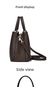 Detail view of large brown monogram crossbody bag with golden hardware and leather straps