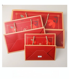 Detailed view of red Chinese wedding gift bags with floral patterns and Xi character
