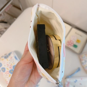 Interior view showing the capacity of a floral cotton makeup bag with cosmetics