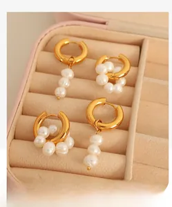 Détail de boucles d'oreilles vintage en perles dans une boîte à bijoux rose