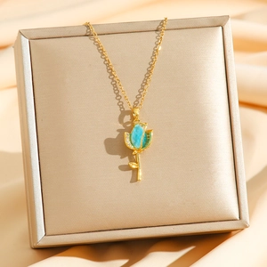 Gros plan d'un collier tulipe dorée avec opale bleue et zircons sur fond de satin