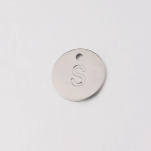 Macro shot of 12mm stainless steel mirror finish round pendant with engraved letter S