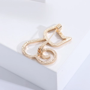 Nahaufnahme einer minimalistischen goldenen Katzenbrosche mit edlem mattem Metallfinish