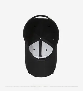 Detail view of black baseball cap interior with white lining and distressed brim edge