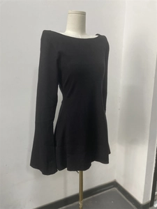 Detail of elegant black long-sleeve dress with wide neckline and subtle flare cuffs