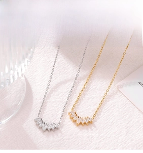 Close-up of gold and silver fan-shaped petal pendant necklaces with sparkling zircons