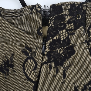 Macro detail of black lace mini dress showing floral patterns and hidden zipper